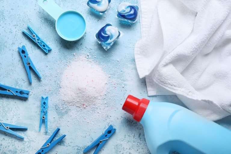 A collection of cleaning supplies, including detergent and a towel, arranged on a blue background.