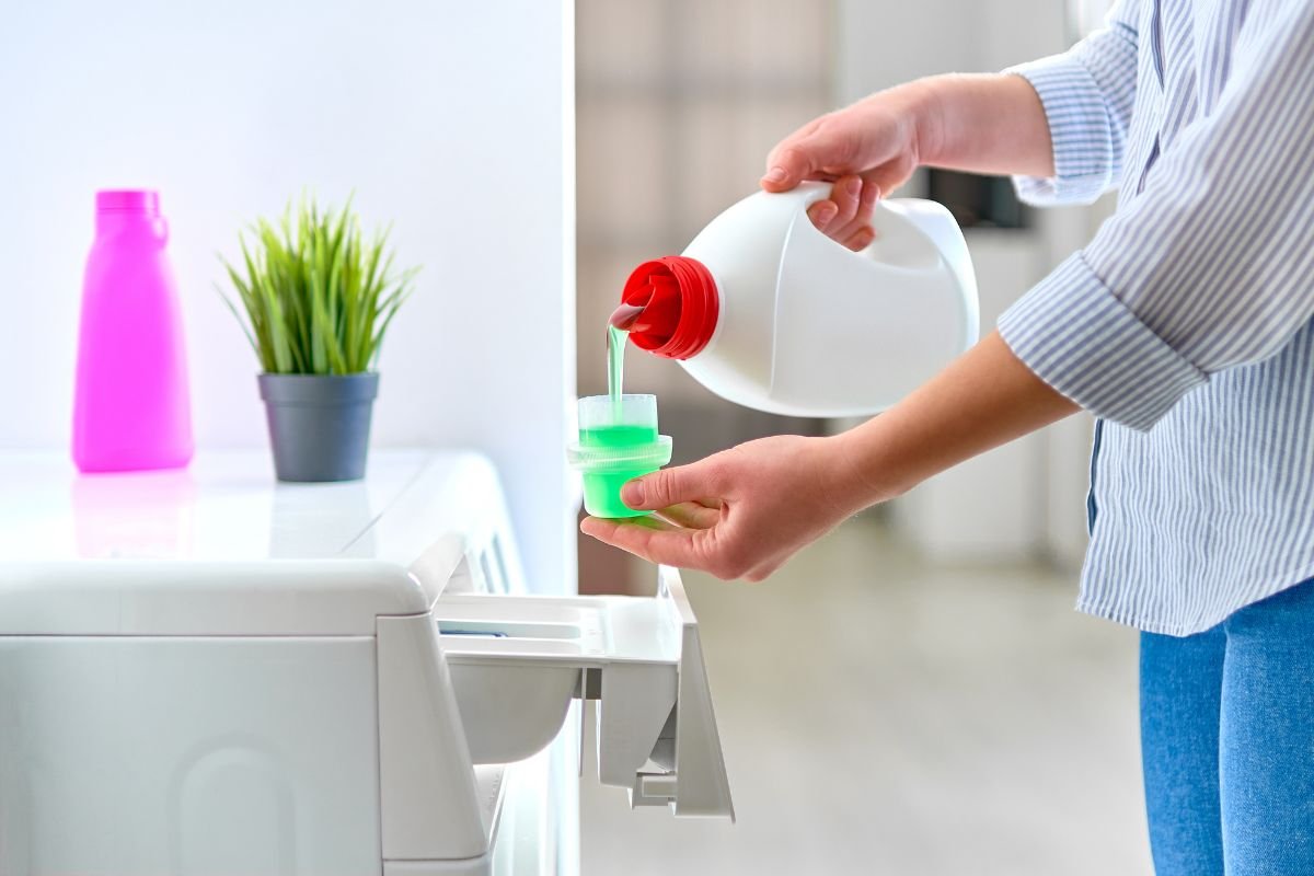 A woman is engaged in pouring a liquid from a vessel into a container, showcasing her attention to detail.